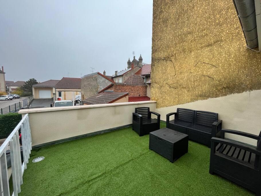 a balcony with chairs and green grass on a building at Duplex belle pierre in Digoin