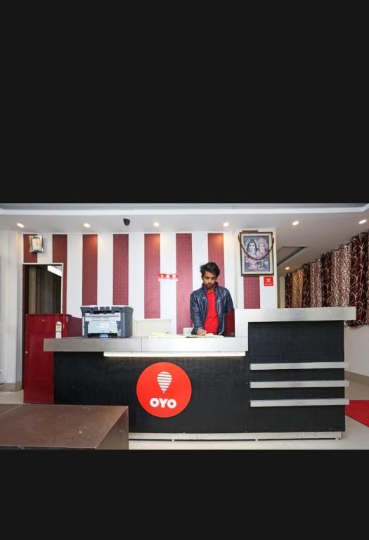 a man standing at a counter in a restaurant at Hotel Best stay haridwar by Shiva Palace in Haridwār