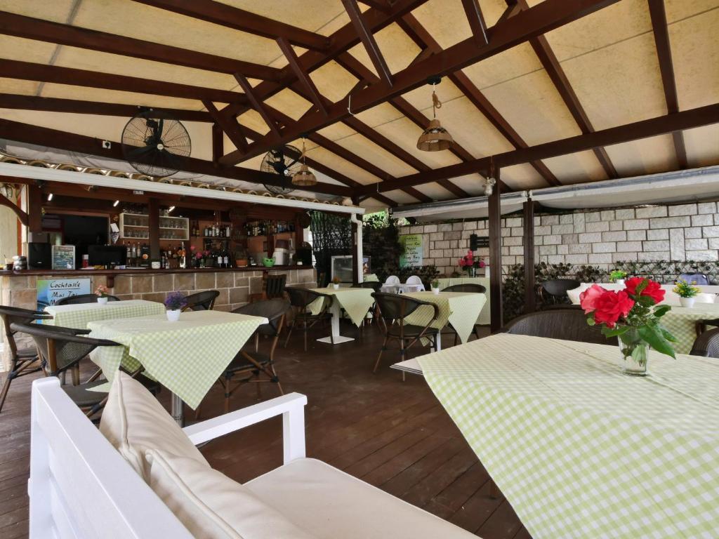 a restaurant with tables and chairs with flowers on them at Bella Vista Hotel Studios & Apartments in Parga