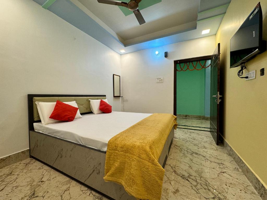 a bedroom with a bed with red pillows and a tv at Hotel Nalanda City in Nalanda