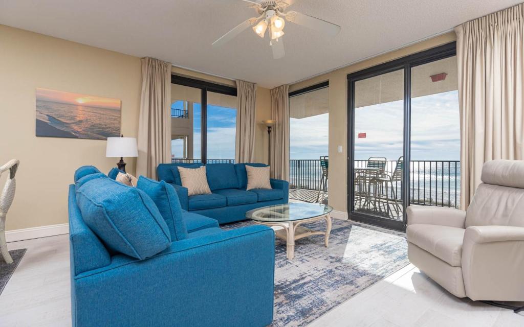 a living room with a blue couch and a table at Phoenix X 317 in Orange Beach