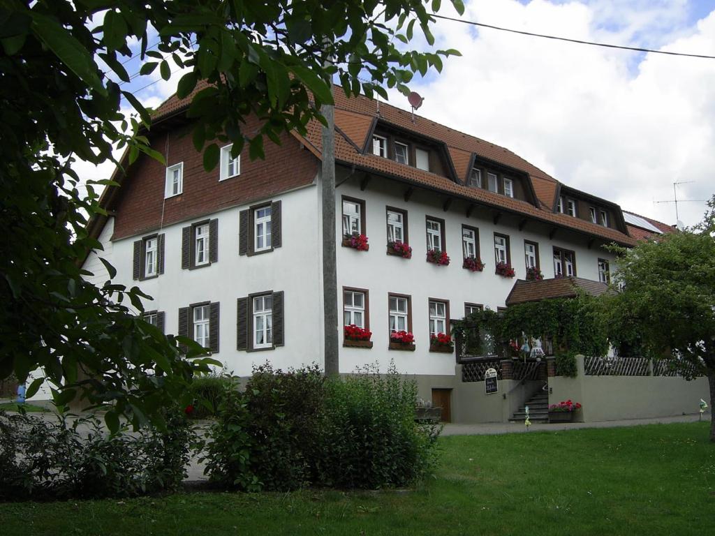 un gran edificio blanco con flores rojas en las ventanas en Gasthaus zum Schwanen, en Ühlingen-Birkendorf