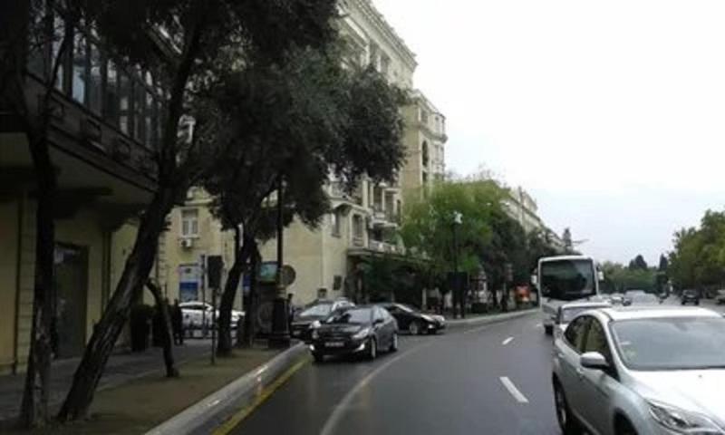 a city street with cars parked on the side of the road at Neftiannikov Avenue Apartment in Baku