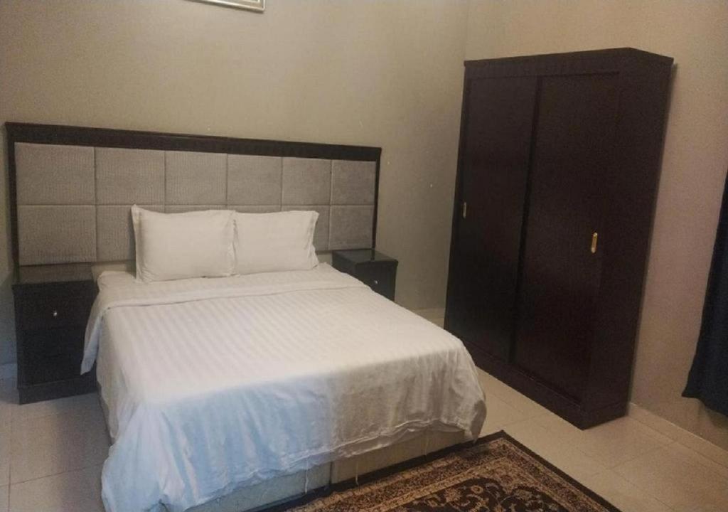 a bedroom with a large bed and a cabinet at نجمة الحسناء in Jeddah