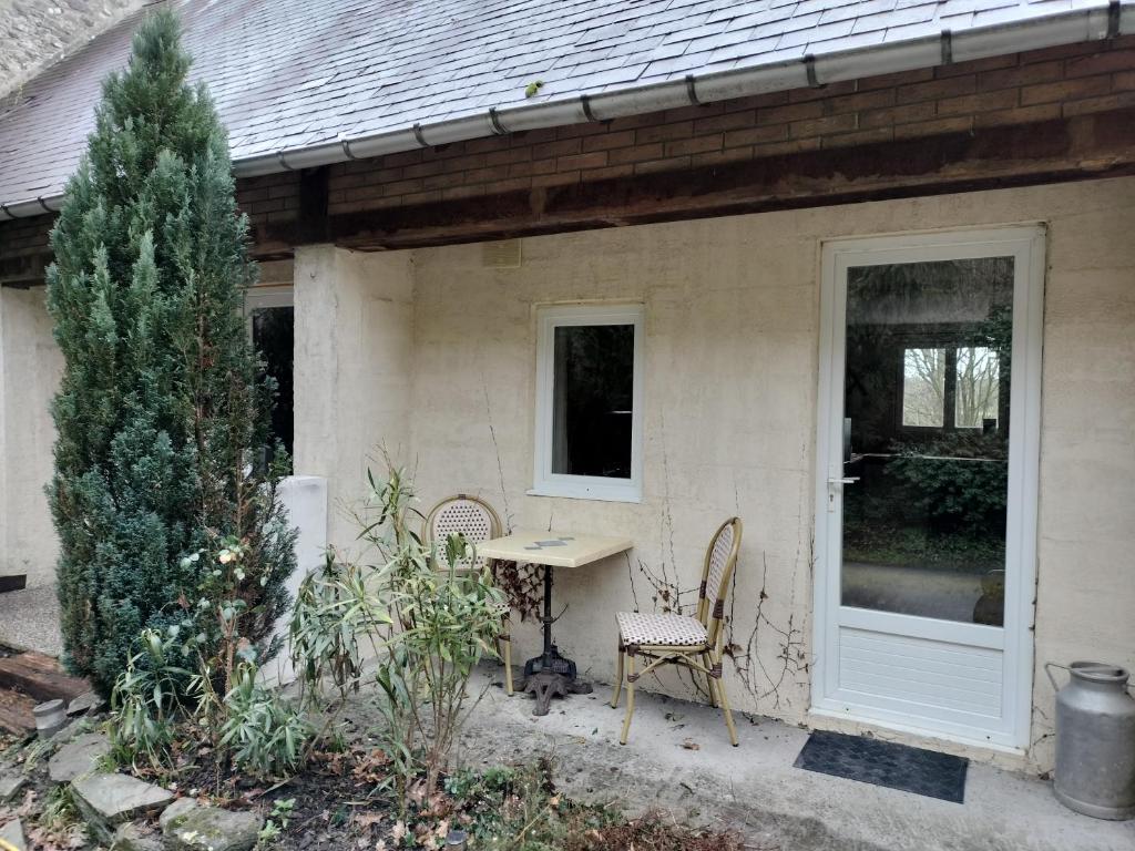ein Haus mit einem Tisch, 2 Stühlen und einer Tür in der Unterkunft Le halage 65 m2 in Baudre