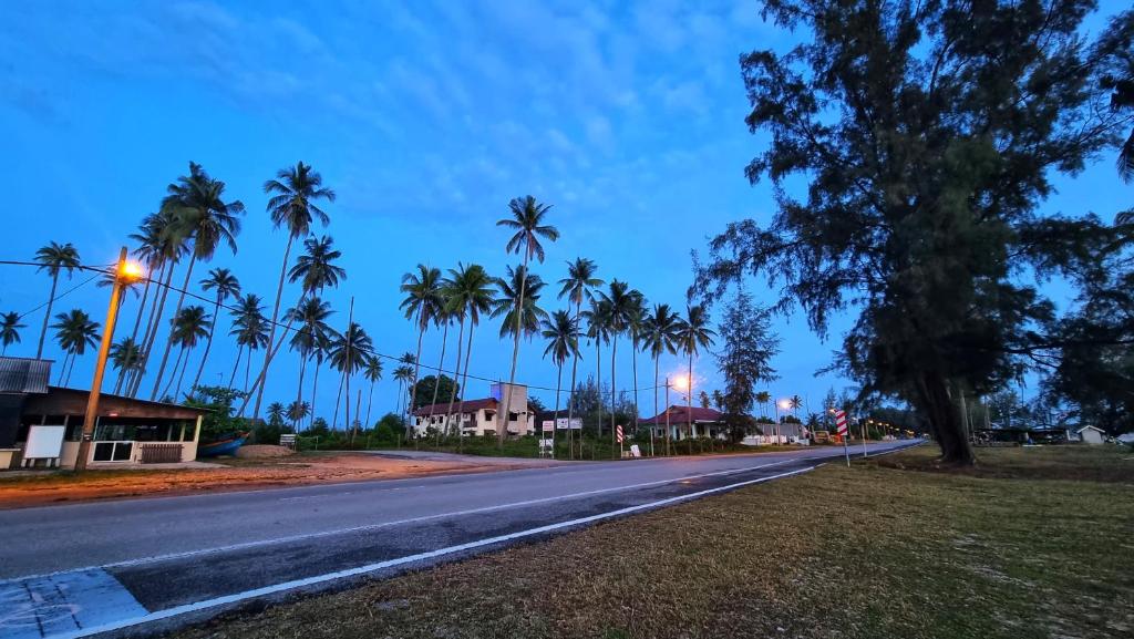 a street with palm trees on the side of a road at RUMAH TAMU TEPI PANTAI in Dungun