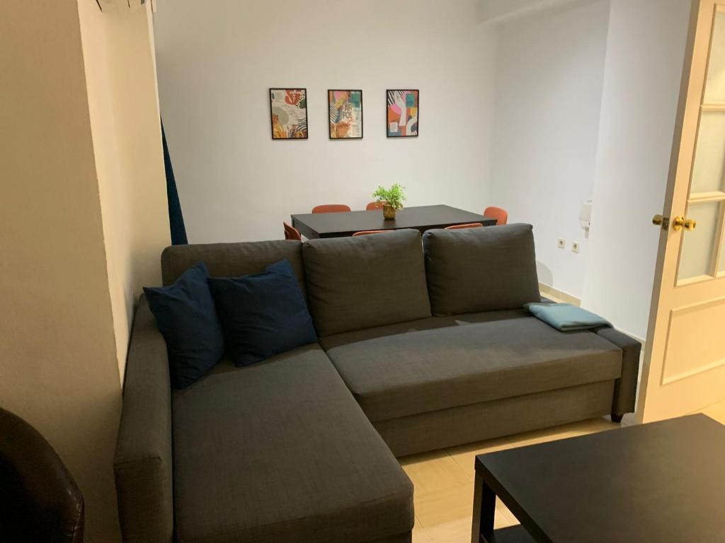 un soggiorno con divano e tavolo di Apartamento cinta 3 habitaciones a Siviglia