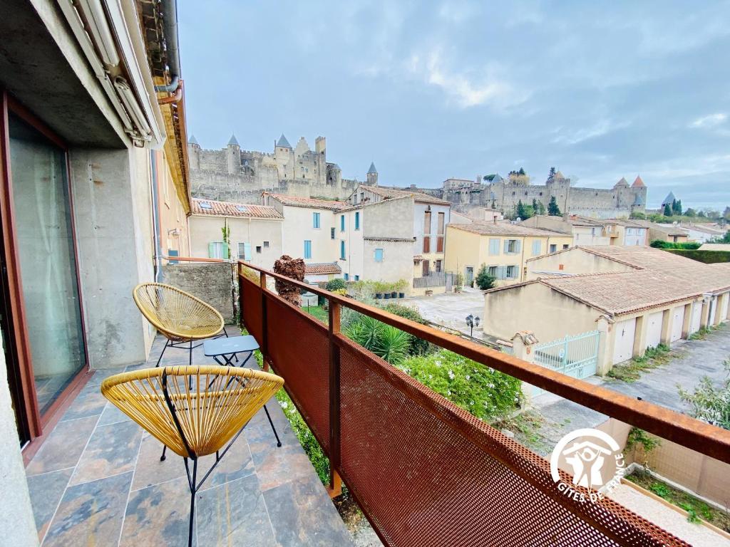a balcony with a chair and a view of a city at Loft cocon climatisé - Imprenable vue sur le château Comtal in Carcassonne