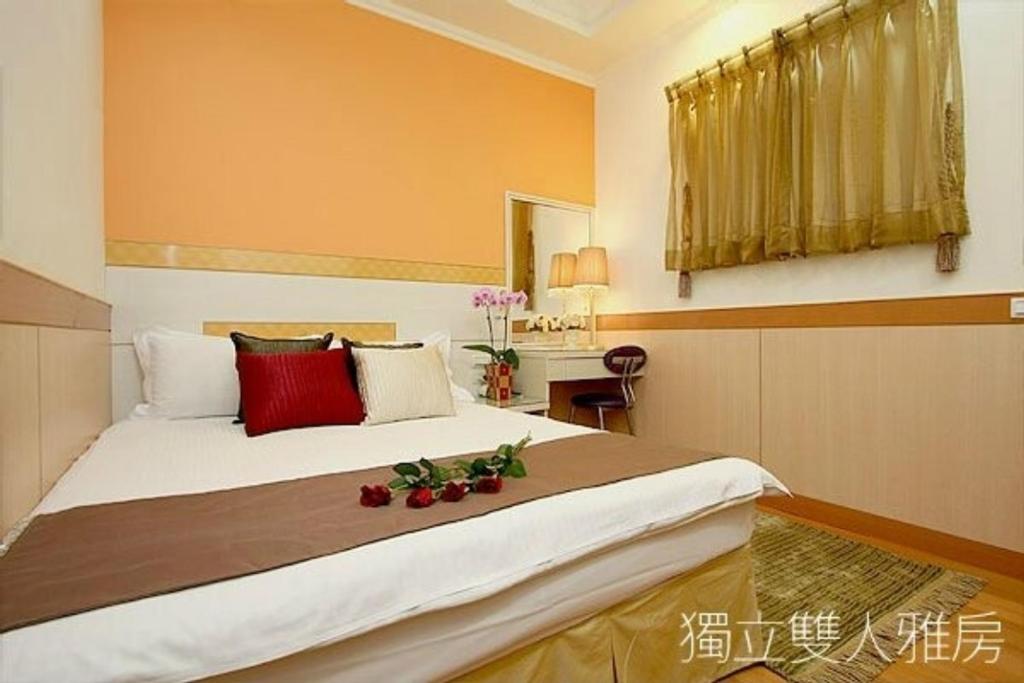 a bedroom with a large bed with red pillows at Hualien Hai Bin Homestay in Hualien City