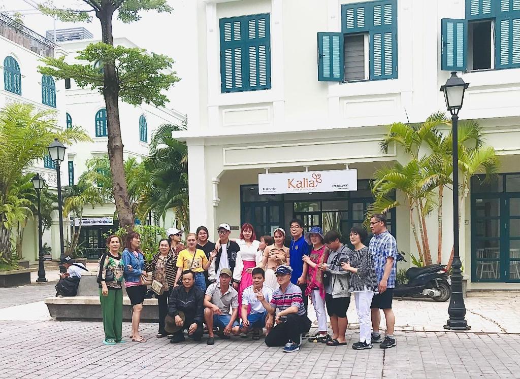 um grupo de pessoas posando para uma foto em frente a um edifício em Kalia Hotel em Phu Quoc