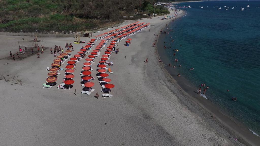 una vista aérea de una playa con una línea de sombrillas en Villaggio La Feluca, en Isca sullo Ionio