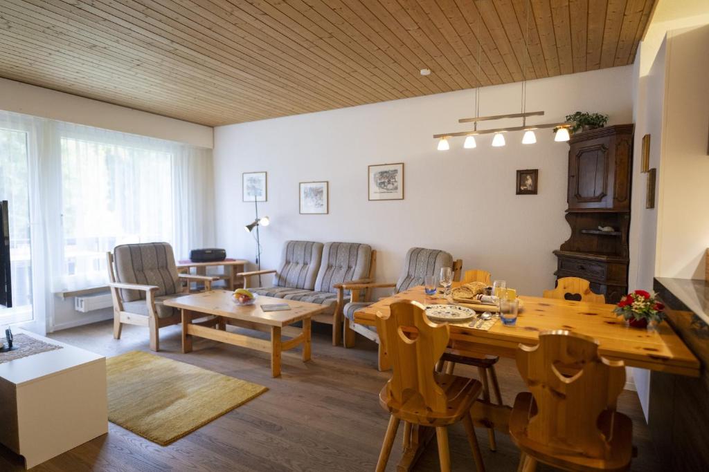 - un salon avec une table et des chaises dans l'établissement Brentschpark Wohnung C 96, à Scuol