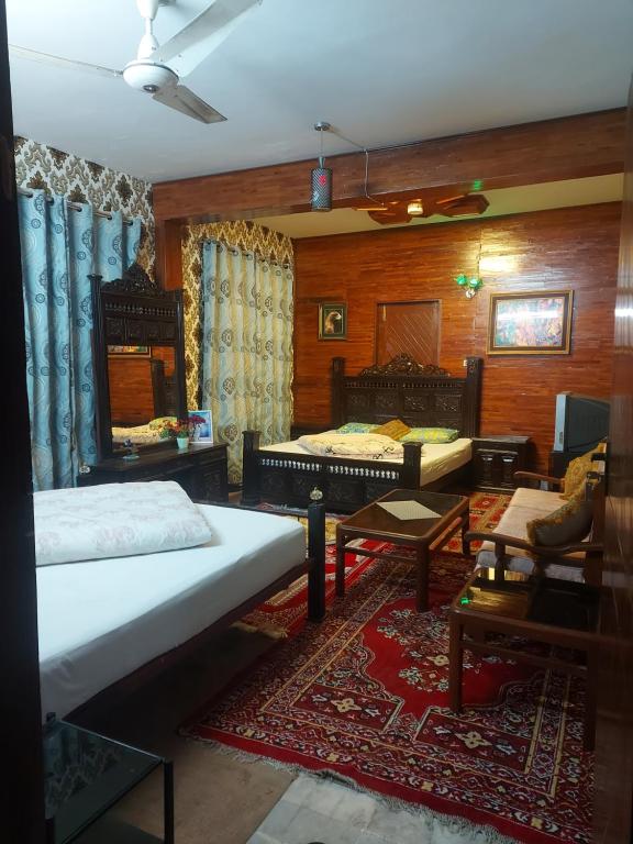 1 dormitorio con 2 camas y sala de estar en Bhurban valley guest house, en Murree