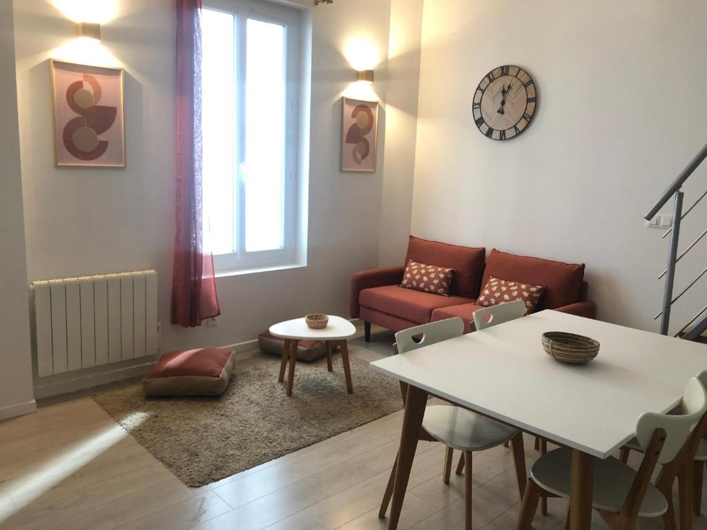 a living room with a table and a couch at Appartements coeur de ville de Vichy in Vichy