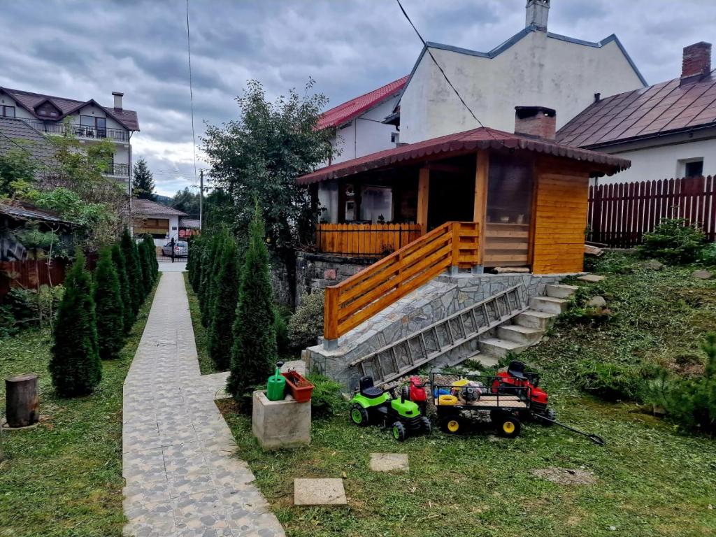 una piccola casa con un portico e alcuni giocattoli sull'erba di Casa La Buni a Buşteni