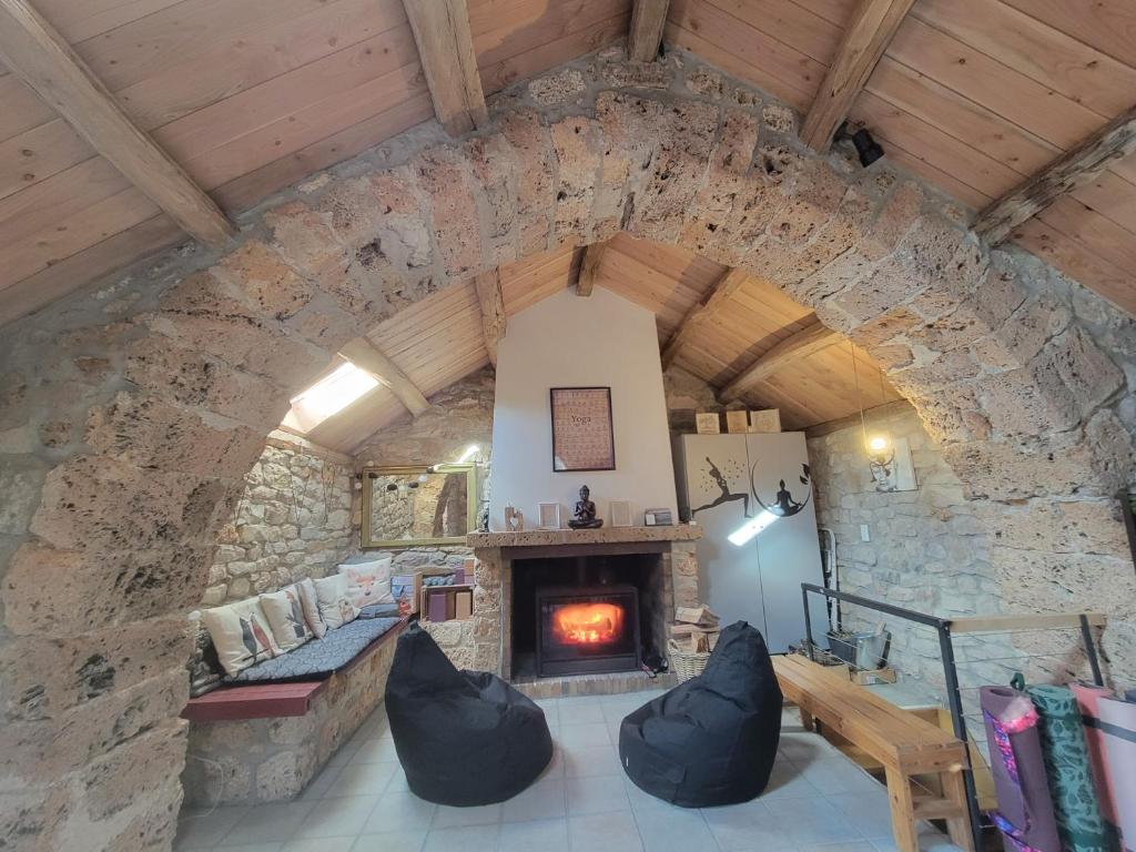 - une cheminée en pierre dans une pièce dotée d'un mur en pierre dans l'établissement Maison des biches, à Saint-Jean-et-Saint-Paul