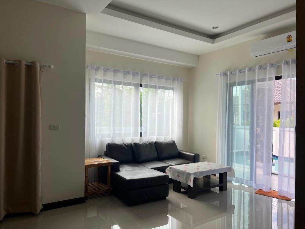 - un salon avec un canapé et une table dans l'établissement Huahin asset pool villa, à Hua Hin
