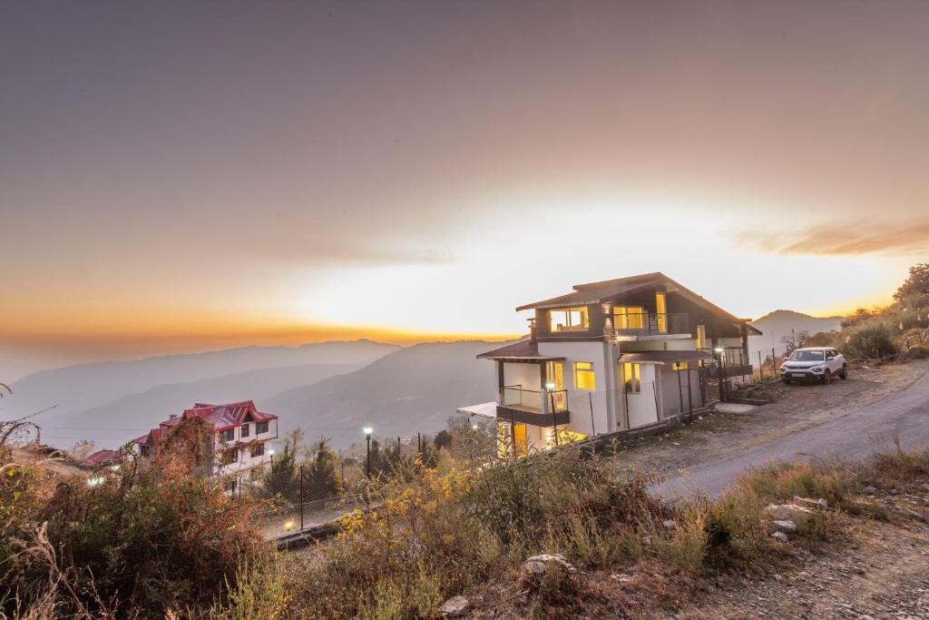 ein Haus an der Seite eines Hügels mit einer Straße in der Unterkunft Hostie Imperial Chalet-3 BHK Mountain Villa, Chail in Shimla