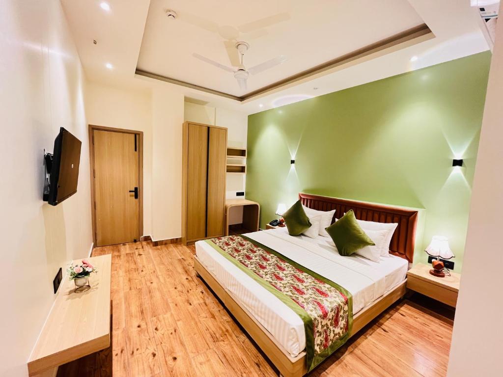 a bedroom with a bed with a green wall at Hotel IP Swarn near Anand Vihar Vaishali Ghaziabad in Ghaziabad