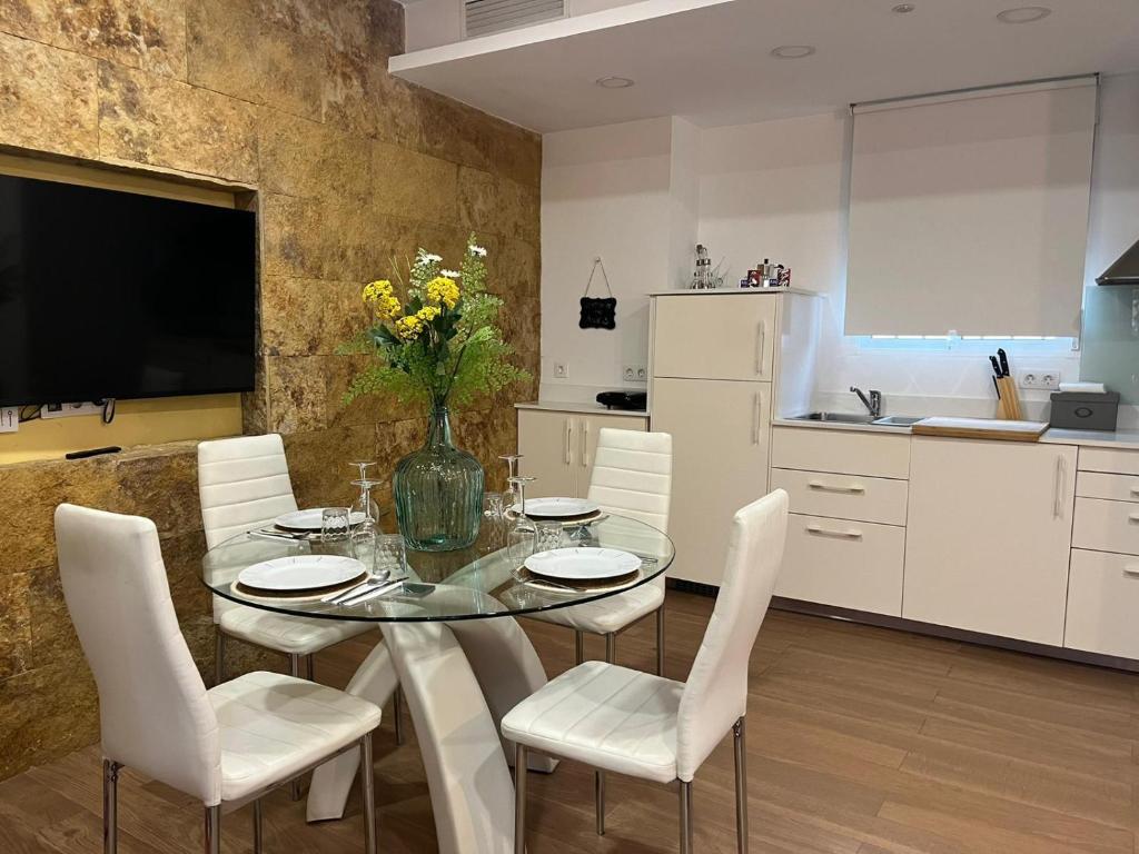 een eetkamer met een glazen tafel en witte stoelen bij Deluxe Artemisa Sevilla in Sevilla