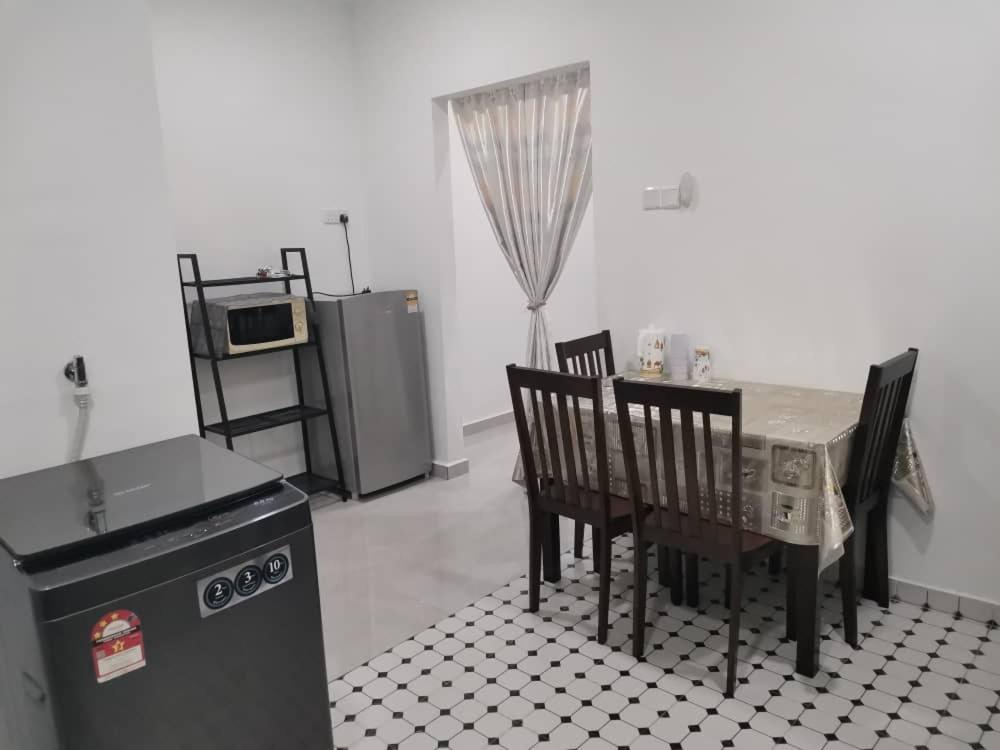 萬津的住宿－D'Parking Homestay Klia Sepang Budget Murah，厨房配有桌椅和冰箱。