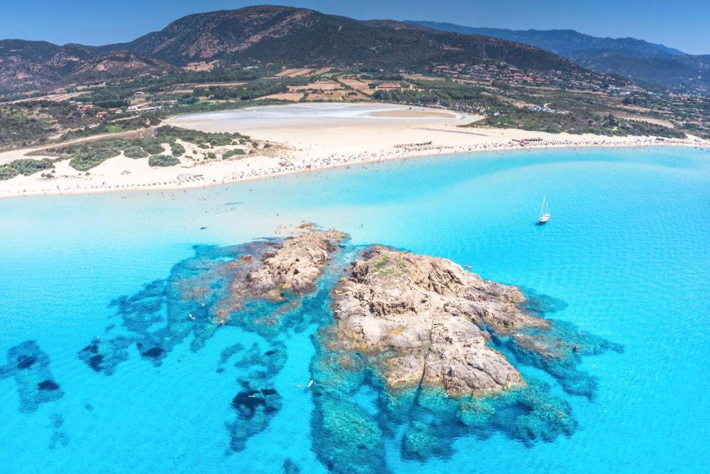 un'isola nell'oceano vicino a una spiaggia di Golf & Sea Residence Is Molas a Pula