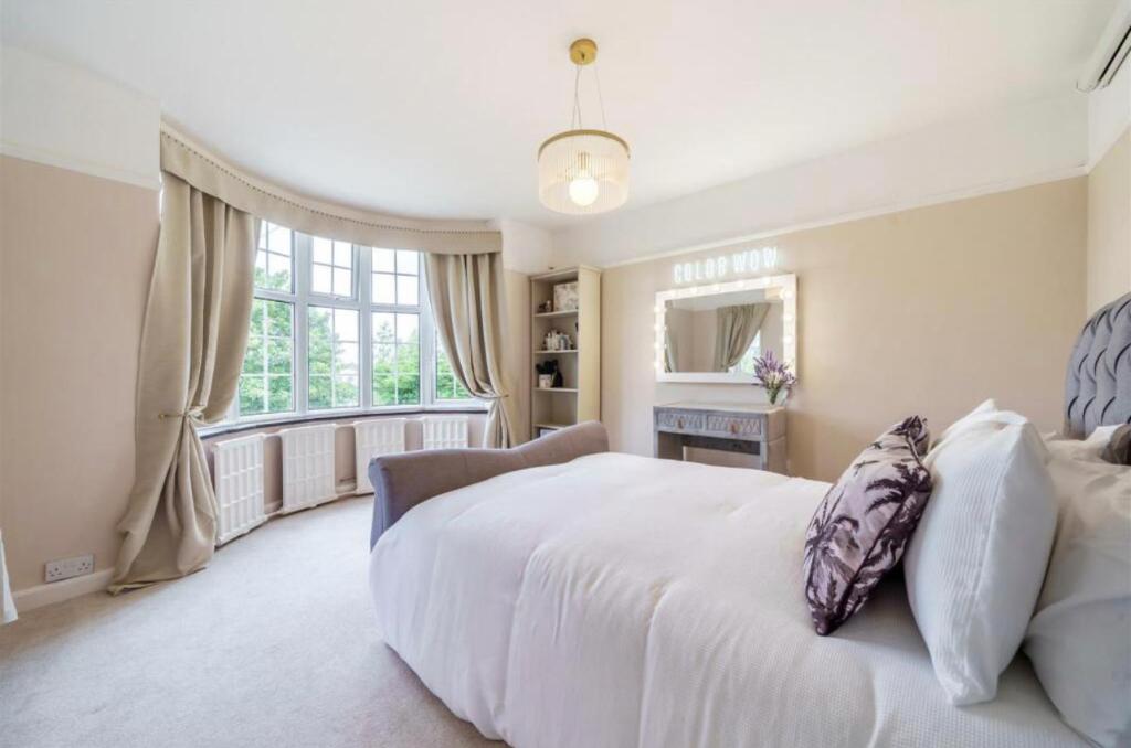 - une chambre avec un grand lit blanc et une fenêtre dans l'établissement Luxury Hot Tub Home Torquay, à Torquay