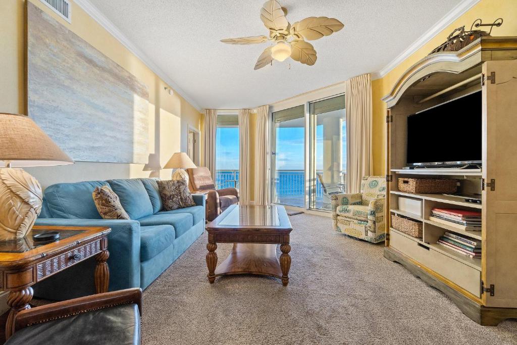een woonkamer met een blauwe bank en een tv bij Palacio 602 in Perdido Key