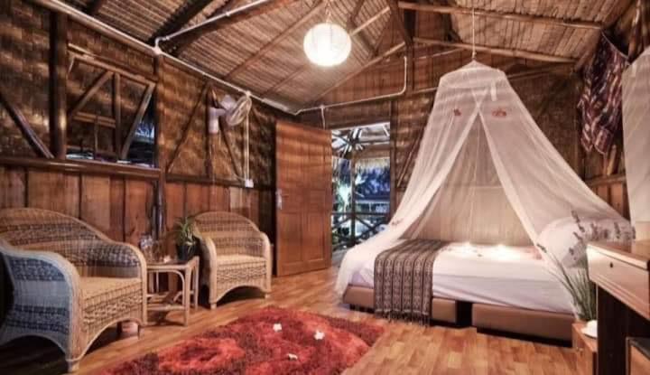 um quarto com uma cama e uma rede mosquiteira em Bintan Brzee Beach in Bintan Island - Bungalow 2 em Berakit