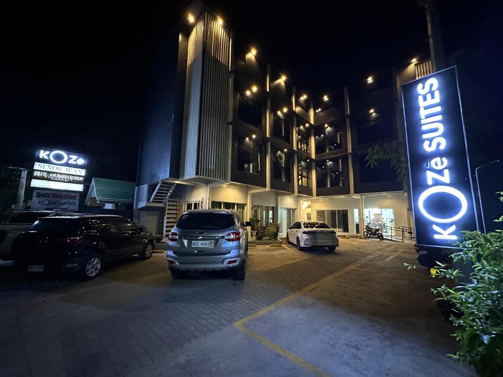 a parking lot in front of a hotel at night at Koze Suites in Dumaguete