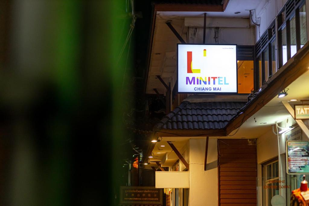 ein Zeichen für das Amt an der Seite eines Gebäudes in der Unterkunft L'MINITEL in Chiang Mai