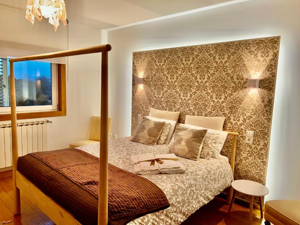 アヴェイロにあるPassadiços da Riaのベッドルーム1室(天蓋付きベッド、シドウサイド付)