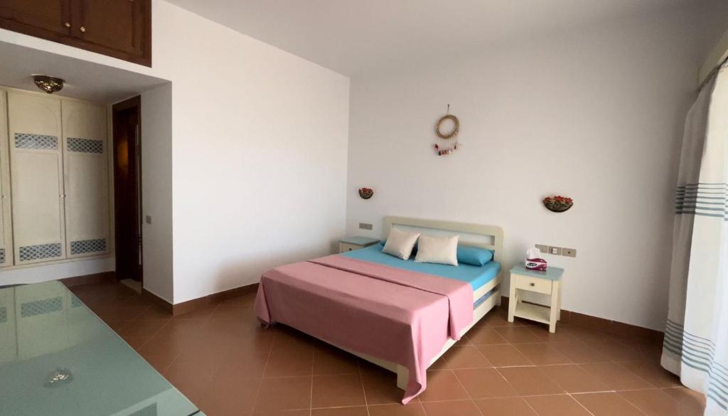 沙姆沙伊赫La Vista Mare Domina Coral Bay的带床和桌子的卧室