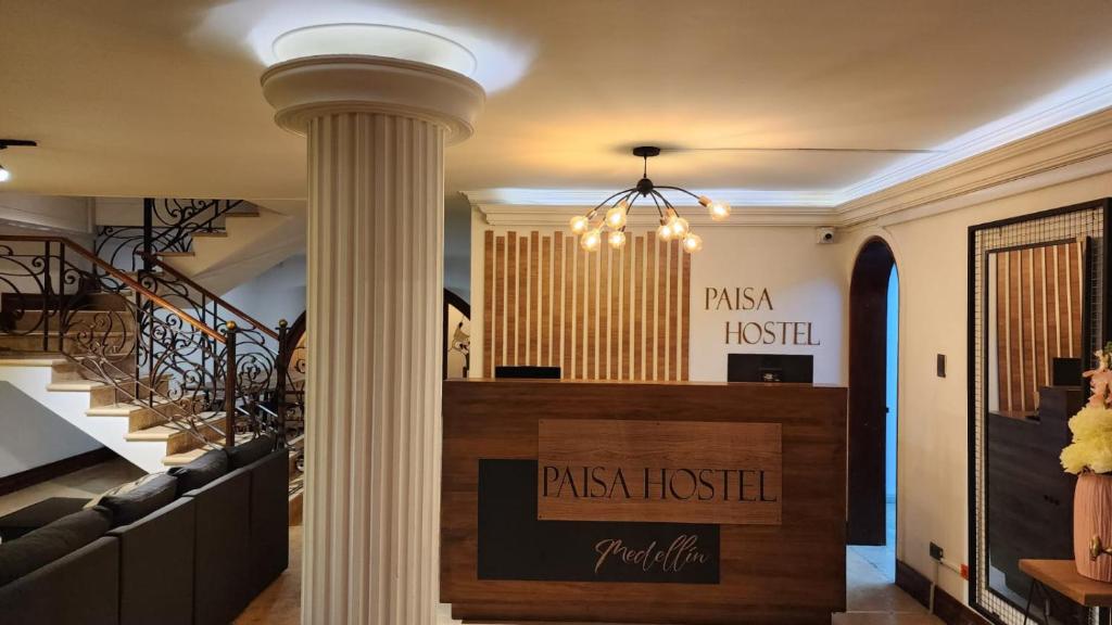 a lobby with a pillar and stairs in a building at Paisa Hostel Medellín in Medellín