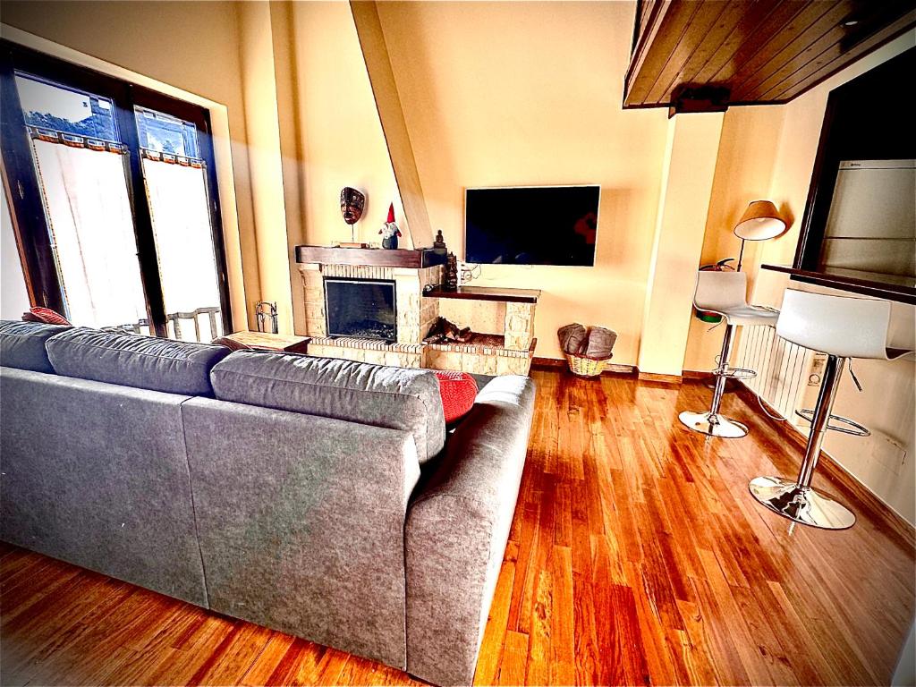 sala de estar con sofá y chimenea en Ático duplex a pie de pistas de esquí, en La Molina