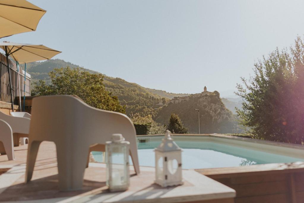 uma piscina com uma cadeira e uma vela ao lado em La Tana dei Tassi em Ascoli Piceno
