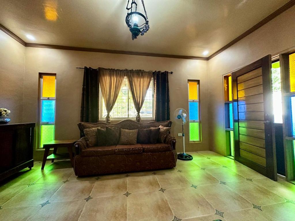 sala de estar con sofá y ventana en Shawn's Transient House at New Clark City en Calingcuan