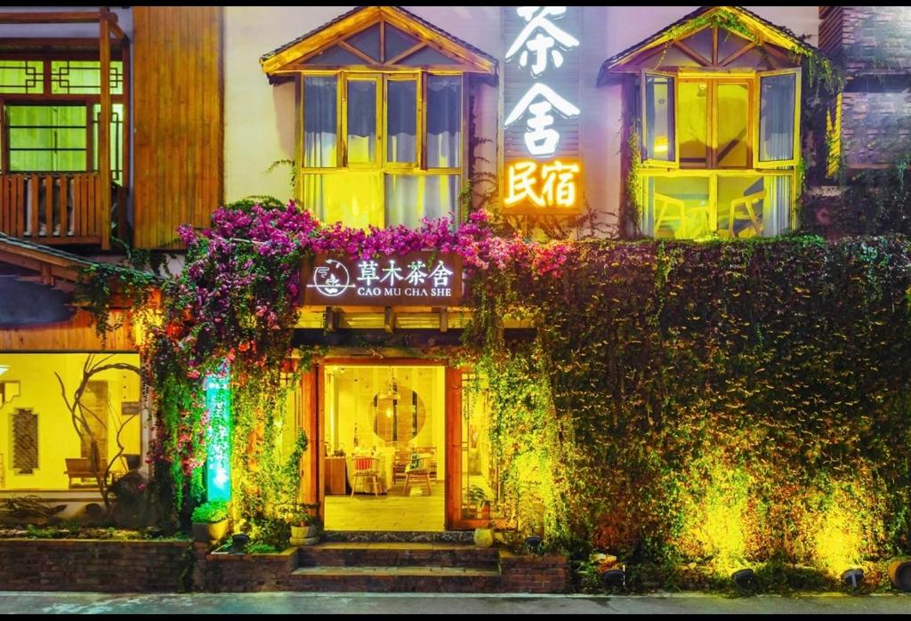 un edificio con flores a un lado. en Tea House, en Zhangjiajie