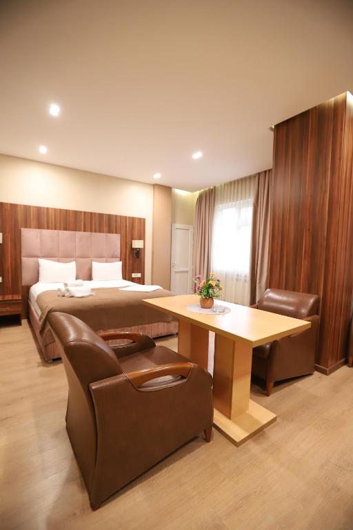 ein Hotelzimmer mit einem Bett, einem Tisch und Stühlen in der Unterkunft Park Suite Hotel in Baku