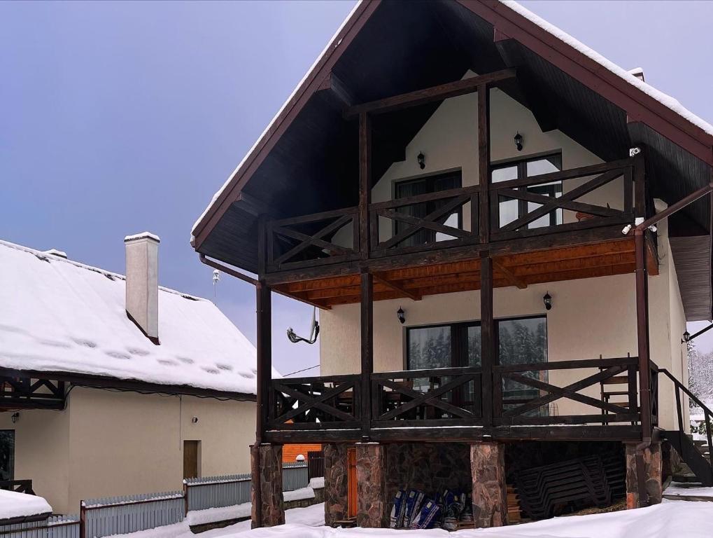 eine Skihütte mit Schnee auf dem Dach in der Unterkunft Belvedere-Karpaty in Schidnyzja