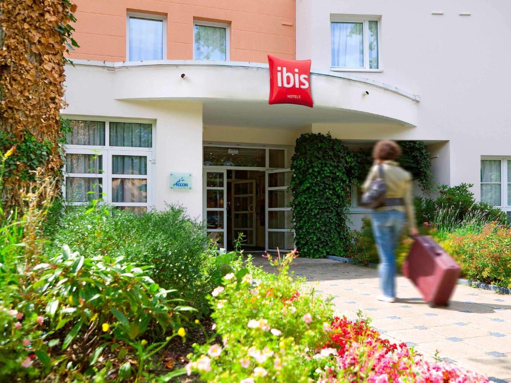 a person walking in front of a building with a ups sign at ibis Nancy-Brabois in Vandoeuvre-lès-Nancy