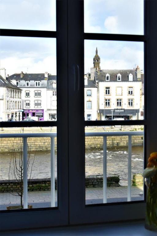 a window with a view of the water and buildings at La Maison du Quai Triplex de charme 4 étoiles en hyper centre avec SPA in Landerneau