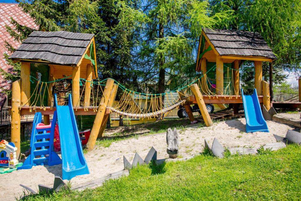 a playground with a slide and a play house at Pod Modrzewiami in Zakopane