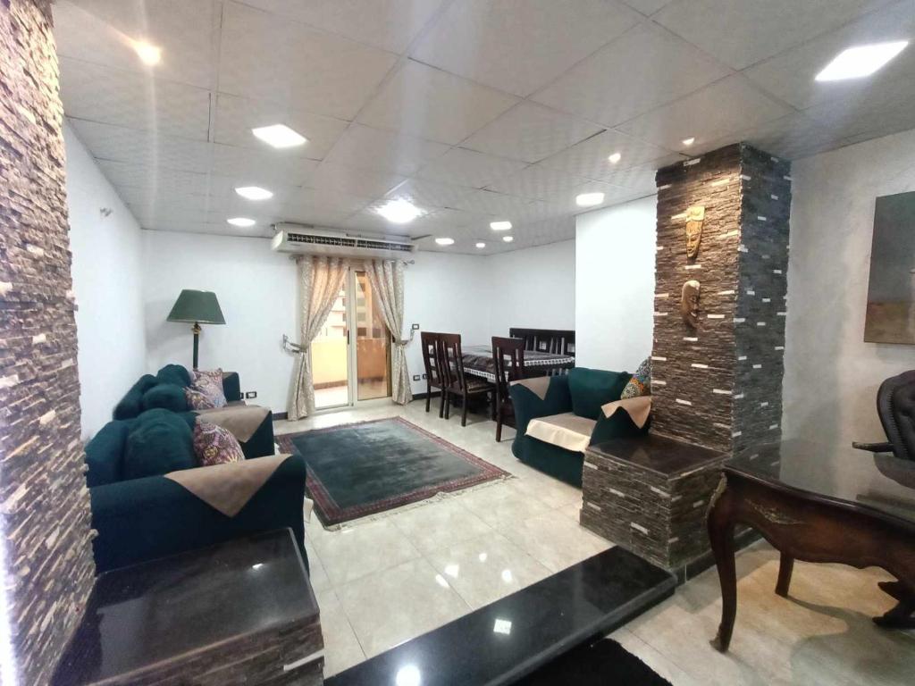 uma sala de estar com sofás e cadeiras e uma mesa em شقه مفروشه كورنيش المعادى no Cairo