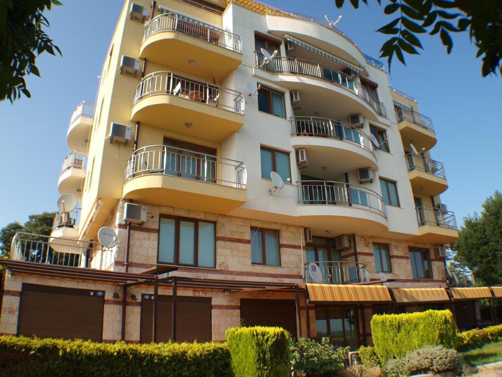 an apartment building with balconies and bushes at Nessebar View Apartament in Nesebar