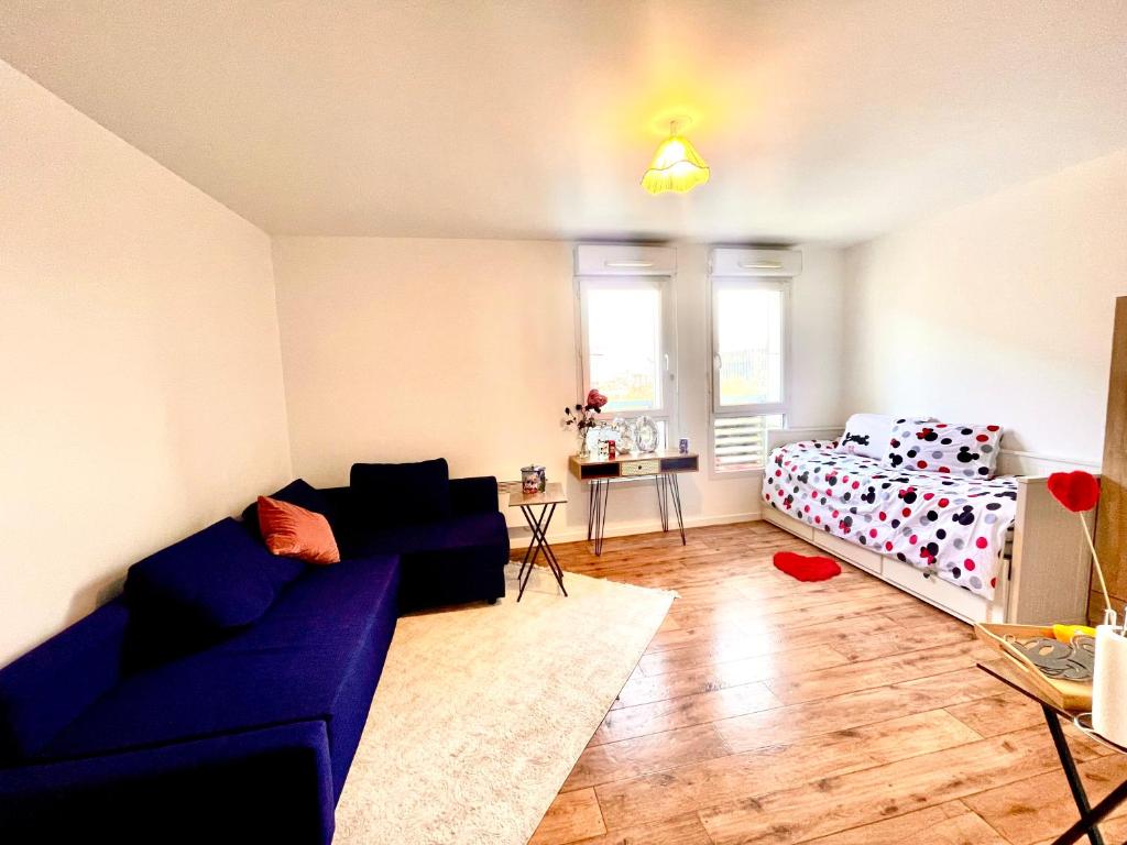 a living room with a blue couch and a bed at 5 Min from Disneyland cozy retreat in Montévrain