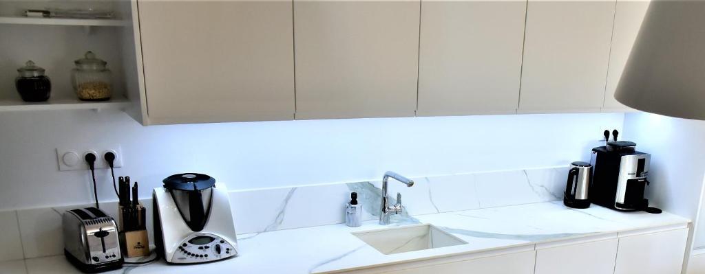 a kitchen with white cabinets and a white counter top at La Maison du Quai Triplex de charme 4 étoiles en hyper centre avec SPA in Landerneau