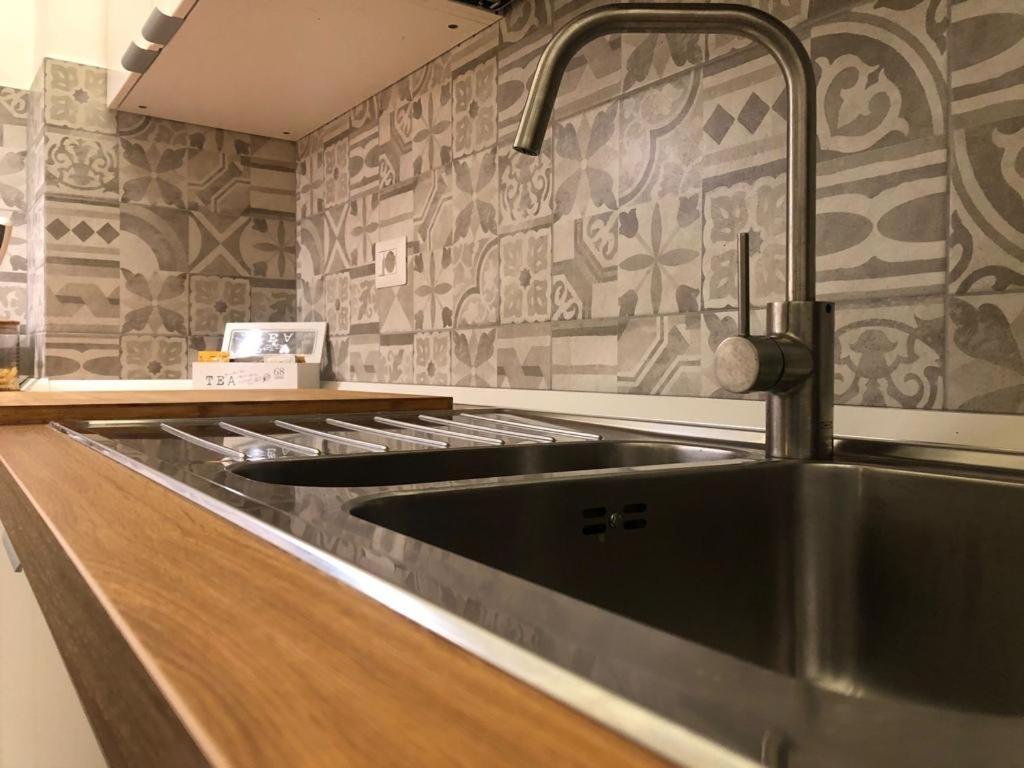 a kitchen with a stainless steel kitchen sink at Maison Bohémienne in Livorno