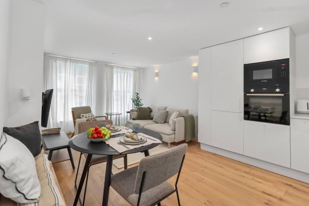 een woonkamer met een tafel en stoelen en een woonkamer bij Cool Apartment Close to Eastbourne Town Centre in Eastbourne