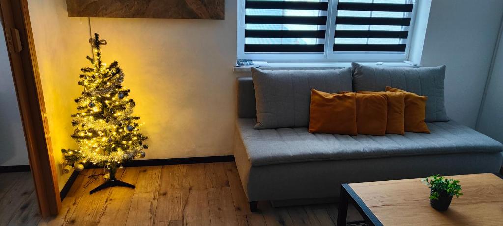 una sala de estar con un árbol de Navidad y un sofá azul en Apartmán 604, en Vrbno pod Pradědem